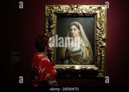 Un employé de la galerie pose avec de l'huile sur toile 'Portrait d'Une femme ('la Donna Velata')', datant d'environ 1513-14 par l'artiste italien de la Renaissance Raphaël (1483-1520), lors d'un aperçu de la presse pour 'The Credit Suisse Exhibition: Raphaël' au Musée national de Londres, Angleterre, sur 4 avril 2022. L'exposition, retardée en raison de la pandémie Covid-19 et marquant le 500th anniversaire de la mort de Raphaël en 2020, est ouverte au public de 9 avril à 31 juillet cette année. NOTE: IMAGES EMBARGOS POUR PUBLICATION JUSQU'à 0001 heure du Royaume-Uni MERCREDI 6 AVRIL 2022 (photo par David Cliff/NurPhoto) Banque D'Images