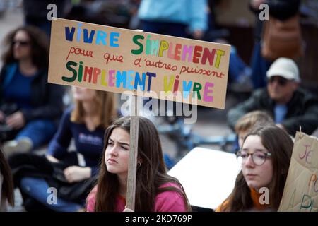 Une jeune femme tient une lecture de carton "vivre simplement pour les autres pourrait simplement vivre". La veille du premier tour de l'élection présidentielle française, des centaines de collectifs ont appelé à « l'arche de l'avenir » dans toute la France pour rappeler aux candidats à la présidence toute la crise qui se produit maintenant : climat, biodiversité, guerres, inégalités croissantes, santé, Extinction des espèces, etc. À Toulouse, plus de 30 organisations ont appelé à la « arche pour l'avenir » (NousToutes, XR, YFC, Greenpeace...) et à former une chaîne humaine. Plusieurs milliers de personnes sont venues et ont formé une chaîne humaine pour aller jusqu'au tow Banque D'Images