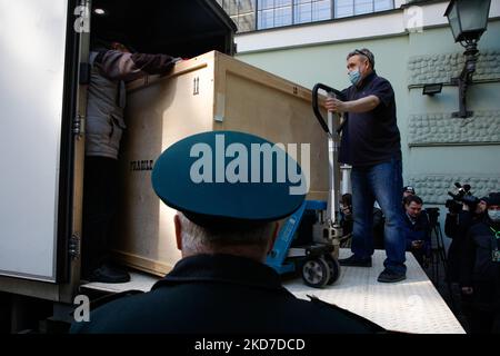 Un agent des douanes russe regarde les travailleurs déchargeant des boîtes d'expositions retournées d'une exposition en Italie dans la cour du musée de l'Ermitage à Saint-Pétersbourg, en Russie, lundi, 11 avril 2022. (Photo de Valya Egorshin/NurPhoto) Banque D'Images