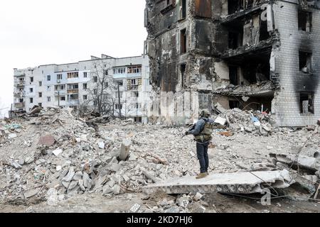 Un militaire patrouille sur les ruines de bâtiments détruits par des bombardements russes, dans le cadre de l'invasion de l'Ukraine par la Russie, à Borodyanka, dans la région de Kiev, en Ukraine, au 13 avril, 2022. (Photo de Sergii Kharchenko/NurPhoto) Banque D'Images