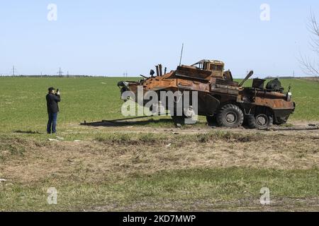 Un homme fait une photo des machines militaires russes détruites sur le terrain agricole près de Kiev, Ukraine, 15 avril 2022 (photo de Maxym Marusenko/NurPhoto) Banque D'Images