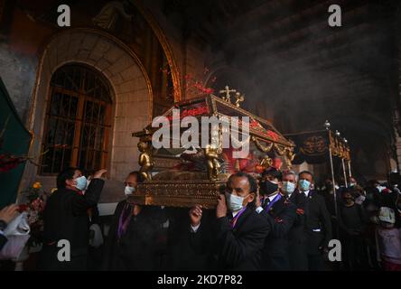 Les dévotés parsement de pétales sur le Saint-Sépulcre / Saint-Sépulcro (une statue grandeur nature du corps crucifié de Jésus dans un cercueil en verre), qui est porté à travers le cloître principal de la basilique lors de la célébration du Vendredi Saint à la Basilique de la Merced à Cusco. Le cortège officiel de la Plaza de Armas à Cusco a été annulé en raison de la pandémie de Covid-19. Le vendredi 15 avril 2022, à Cusco, Pérou. (Photo par Artur Widak/NurPhoto) Banque D'Images