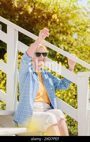 Mature femme attrayante voyageur assis seul sur la terrasse du café de plage Banque D'Images