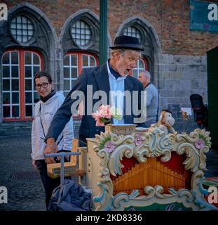 Un artiste de rue jouant l'orgue de tonneau sur la place principale de la ville de Bruges en Belgique Banque D'Images