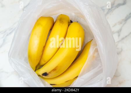 Goias, Brésil – 05 novembre 2022 : un bouquet de bananes dans un sac en plastique sur la table. Banque D'Images