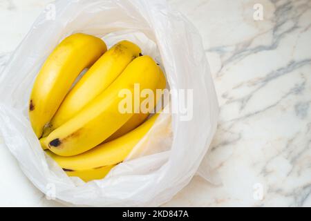 Goias, Brésil – 05 novembre 2022 : un bouquet de bananes dans un sac en plastique sur la table. Banque D'Images