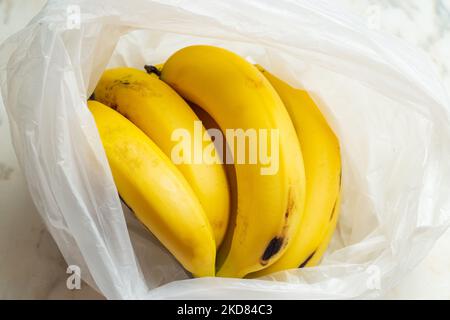 Goias, Brésil – 05 novembre 2022 : un bouquet de bananes dans un sac en plastique sur la table. Banque D'Images