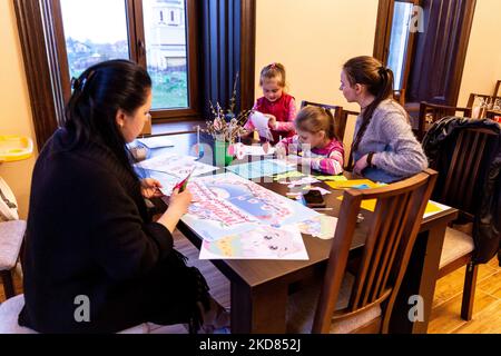 Le volontaire ukrainien Krystyna prépare des décorations de Pâques avec des réfugiés domestiques qui se sont échappés de la région de Kharkiv à la sécurité relative de Nadyby, oblast de Lviv, Ukraine sur 21 avril 2022. Depuis que la Fédération de Russie a envahi l'Ukraine, le conflit a forcé plus de 10 millions de personnes à fuir leurs foyers, tant à l'intérieur qu'à l'extérieur. L'église grecque-catholique de Nadyby, près de Lviv, accueille des dizaines de mères avec enfants qui ont fui la guerre dans l'est de l'Ukraine et qui soutient beaucoup plus de réfugiés dans la région. Les familles ont trouvé refuge au Centre de soins pastoraux des prêtres et des moines à Nadyby. (Photo de Domi Banque D'Images