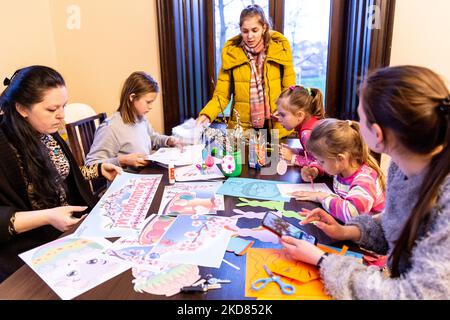 Le volontaire ukrainien Krystyna, Maria et Mariana préparent des décorations de Pâques avec des réfugiés domestiques qui se sont échappés de la région de Kharkiv à la sécurité relative de l'oblast de Lviv, Ukraine sur 21 avril 2022. Depuis que la Fédération de Russie a envahi l'Ukraine, le conflit a forcé plus de 10 millions de personnes à fuir leurs foyers, tant à l'intérieur qu'à l'extérieur. L'église grecque-catholique de Nadyby, près de Lviv, accueille des dizaines de mères avec enfants qui ont fui la guerre dans l'est de l'Ukraine et qui soutient beaucoup plus de réfugiés dans la région. Les familles ont trouvé refuge au Centre de soins pastoraux des prêtres et des moines à Nadyby. (Pho Banque D'Images