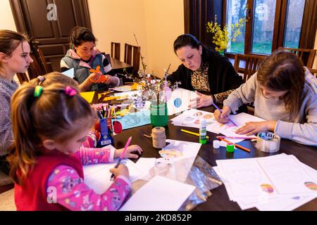 Le volontaire ukrainien Krystyna prépare des décorations de Pâques avec des réfugiés domestiques qui se sont échappés de la région de Kharkiv à la sécurité relative de Nadyby, oblast de Lviv, Ukraine sur 21 avril 2022. Depuis que la Fédération de Russie a envahi l'Ukraine, le conflit a forcé plus de 10 millions de personnes à fuir leurs foyers, tant à l'intérieur qu'à l'extérieur. L'église grecque-catholique de Nadyby, près de Lviv, accueille des dizaines de mères avec enfants qui ont fui la guerre dans l'est de l'Ukraine et qui soutient beaucoup plus de réfugiés dans la région. Les familles ont trouvé refuge au Centre de soins pastoraux des prêtres et des moines à Nadyby. (Photo de Domi Banque D'Images