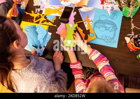 Le volontaire ukrainien Krystyna prépare des décorations de Pâques avec une jeune fille réfugiée qui s'est échappée de la région de Kharkiv à la sécurité relative de Nadyby, oblast de Lviv, Ukraine sur 21 avril 2022. Depuis que la Fédération de Russie a envahi l'Ukraine, le conflit a forcé plus de 10 millions de personnes à fuir leurs foyers, tant à l'intérieur qu'à l'extérieur. L'église grecque-catholique de Nadyby, près de Lviv, accueille des dizaines de mères avec enfants qui ont fui la guerre dans l'est de l'Ukraine et qui soutient beaucoup plus de réfugiés dans la région. Les familles ont trouvé refuge au Centre de soins pastoraux des prêtres et des moines à Nadyby. (Photo par Banque D'Images