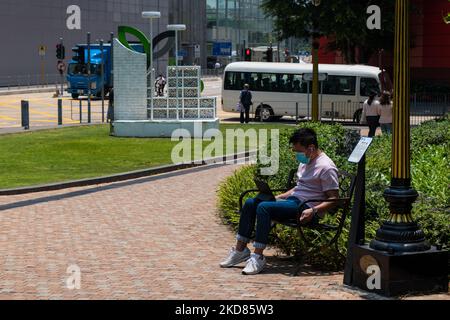 Un homme consulte un appareil portable dans un parc de Kowloon Bay. (Photo de Marc Fernandes/NurPhoto) Banque D'Images