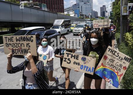 Les activistes de l'environnement branchirent des panneaux et crient des slogans alors qu'ils marchent sur la route principale de la ville lors de la grève mondiale du climat à Bangkok, Thaïlande, 22 avril 2022. (Photo par Anusak Laowilas/NurPhoto) Banque D'Images