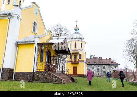 Les fidèles ukrainiens arrivent pour un service du Vendredi Saint dans l'église grecque-catholique de Nadyby, oblast de Lviv, Ukraine sur 22 avril 2022. Alors que la Fédération de Russie envahissait l'Ukraine il y a près de deux mois, le conflit a forcé plus de 10 millions d'Ukrainiens à fuir les zones de guerre, tant à l'intérieur qu'à l'extérieur. L'oblast de Lviv accueille de nombreux réfugiés internes. Le village de Nadyby et son église orthodoxe grecque sont devenus un refuge pour des dizaines de réfugiés de Kharkiv, Donesk et Zaporizhzhia Oblast. Alors que les fidèles ukrainiens se réunissent pour les célébrations orthodoxes de Pâques, les chrétiens locaux et les réfugiés célèbrent la toge de Pâques Banque D'Images