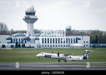 LOT Polish Airlines plane and Polish Air navigation Services Agency (en arrière-plan) à l'aéroport Chopin de Varsovie, Pologne sur 22 avril 2022. La grève et les démissions massives de contrôleurs de la circulation aérienne de l'Agence polonaise des services de navigation aérienne entraînent de nombreux retards et ont annulé des vols dans l'espace aérien polonais. (Photo de Mateusz Wlodarczyk/NurPhoto) Banque D'Images