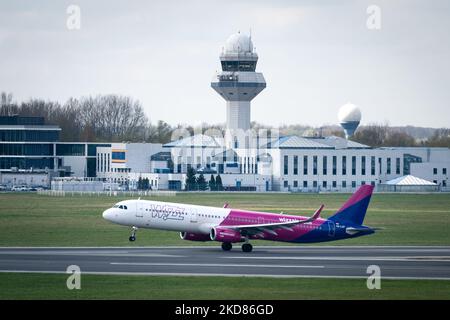 Wizz Air Airbus A321-231 HA-LXP et l'Agence polonaise des services de navigation aérienne (en arrière-plan) à l'aéroport Chopin de Varsovie, en Pologne, sur 22 avril 2022. La grève et les démissions massives de contrôleurs de la circulation aérienne de l'Agence polonaise des services de navigation aérienne entraînent de nombreux retards et ont annulé des vols dans l'espace aérien polonais. (Photo de Mateusz Wlodarczyk/NurPhoto) Banque D'Images