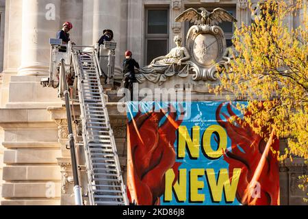 Un membre de la rébellion d'extinction est enlevé par DC Fire après avoir déposé une bannière de la deuxième histoire du bâtiment John Wilson, où se trouvent les bureaux de la ville de Washington. Pour le jour de la Terre, le groupe a organisé un rassemblement et une marche pour protester contre les combustibles fossiles en général, et pour exiger expressément que la ville refuse de permettre à Washington Gas d'étendre ses infrastructures de distribution de méthane. Elle a été enlevée par le service des incendies de DC et immédiatement arrêtée par la police de DC. La rébellion de l'extinction a refusé de donner son nom. (Photo d'Allison Bailey/NurPhoto) Banque D'Images