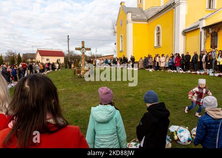 Les fidèles ukrainiens assistent à la cérémonie de bénédiction traditionnelle du panier de nourriture du samedi Saint dans l'église grecque-catholique de Nadyby, oblast de Lviv, Ukraine sur 23 avril 2022. Alors que la Fédération de Russie envahissait l'Ukraine il y a près de deux mois, le conflit a forcé plus de 10 millions d'Ukrainiens à fuir les zones de guerre, tant à l'intérieur qu'à l'extérieur. L'oblast de Lviv accueille de nombreux réfugiés internes. Le village de Nadyby et son église catholique grecque sont devenus un refuge pour des dizaines de réfugiés de Kharkiv, Donesk et Zaporizhzhia Oblast. Comme les fidèles ukrainiens se réunissent pour les célébrations orthodoxes de Pâques, les chrétiens locaux et le RE Banque D'Images