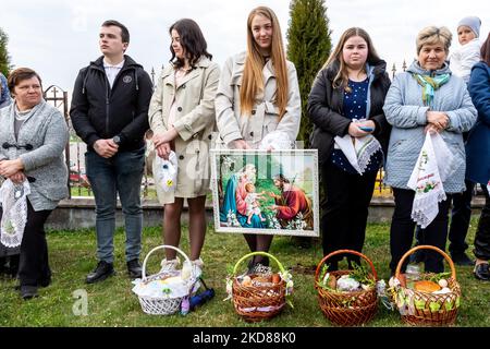 Les fidèles ukrainiens assistent à la cérémonie de bénédiction traditionnelle du panier de nourriture du samedi Saint dans l'église grecque-catholique de Nadyby, oblast de Lviv, Ukraine sur 23 avril 2022. Alors que la Fédération de Russie envahissait l'Ukraine il y a près de deux mois, le conflit a forcé plus de 10 millions d'Ukrainiens à fuir les zones de guerre, tant à l'intérieur qu'à l'extérieur. L'oblast de Lviv accueille de nombreux réfugiés internes. Le village de Nadyby et son église catholique grecque sont devenus un refuge pour des dizaines de réfugiés de Kharkiv, Donesk et Zaporizhzhia Oblast. Comme les fidèles ukrainiens se réunissent pour les célébrations orthodoxes de Pâques, les chrétiens locaux et le RE Banque D'Images