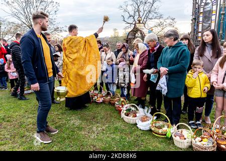 Les fidèles ukrainiens assistent à la cérémonie de bénédiction traditionnelle du panier de nourriture du samedi Saint dans l'église grecque-catholique de Nadyby, oblast de Lviv, Ukraine sur 23 avril 2022. Alors que la Fédération de Russie envahissait l'Ukraine il y a près de deux mois, le conflit a forcé plus de 10 millions d'Ukrainiens à fuir les zones de guerre, tant à l'intérieur qu'à l'extérieur. L'oblast de Lviv accueille de nombreux réfugiés internes. Le village de Nadyby et son église catholique grecque sont devenus un refuge pour des dizaines de réfugiés de Kharkiv, Donesk et Zaporizhzhia Oblast. Comme les fidèles ukrainiens se réunissent pour les célébrations orthodoxes de Pâques, les chrétiens locaux et le RE Banque D'Images