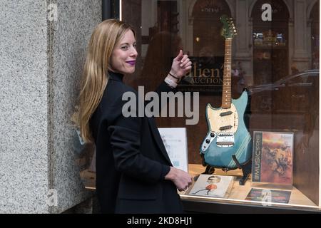 LONDRES, ROYAUME-UNI - 27 AVRIL 2022 : une femme joue une guitare aérienne à côté de la guitare électrique Fender Mustang, gaucher en compétition Lake Placid Blue Finish avec tête correspondante (1969), estimation initiale : $600 000 - $800 000, joué par Kurt Cobain dans la vidéo musicale emblématique de Nirvana “sent like Teen Spirit” avec d'autres objets liés à Kurt Cobain sont exposés dans le Hard Rock Cafe Piccadilly Circus sur 27 avril 2022 à Londres, en Angleterre. Les souvenirs seront offerts par Julien’s Auctions lors de la vente aux enchères DE trois jours DES ICÔNES MUSICALES qui aura lieu entre le 20th et le 22nd mai à Hard Banque D'Images