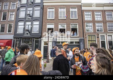 Les jeunes célèbrent le Kings Day avec des fêtes dans les étudiants résidents et les lieux. Les pays-Bas célèbrent la Journée du Roi après deux ans d'annulation en raison de la pandémie du coronavirus COVID-19 et des restrictions et mesures de confinement. Des milliers de gens du coin, de fêtards et de visiteurs ont visité le centre-ville, les parcs près du Rijksmuseum, les canaux d'Amsterdam pour célébrer avec diverses festivités l'anniversaire du roi Willem-Alexander connu sous le nom de Koningsdag, une fête nationale néerlandaise. Tous les types de bateaux et de bateaux sont vus dans les canaux passant sous les célèbres ponts et près des maisons étroites d'Amst Banque D'Images