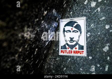 Une affiche avec Vladimir Poutine, représentée sous le nom d'Adolf Hitler et l'expression « Putler Kaput », est vue lors d'une manifestation de solidarité avec l'Ukraine sur la place principale, demandant à l'OTAN de fermer le ciel pour les avions russes sur le territoire de l'Ukraine après l'invasion russe. Cracovie, Pologne sur 2 mai 2022. (Photo de Beata Zawrzel/NurPhoto) Banque D'Images