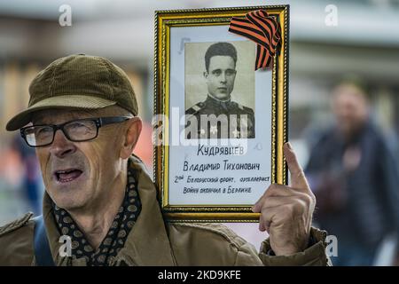 Un homme tient une photo d'un parent tué pendant la Seconde Guerre mondiale pendant la marche du Régiment immortel dans les rues de Moscou. Cette marche avec des photos d'anciens combattants célèbre la victoire soviétique dans la Seconde Guerre mondiale. (Photo par STR/NurPhoto) Banque D'Images