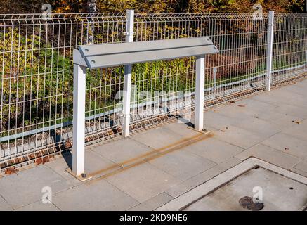 Banc incliné ou support incliné ou barre maigre (pas encore de nom établi) - nouveau remplacement moderne de banc traditionnel sur les gares de chemin de fer, bus ou tramwa Banque D'Images