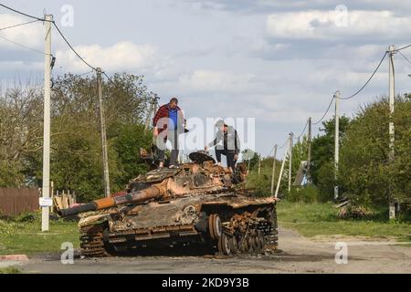 Les hommes locaux explorent le char brûlé dans la rue dans le village de Zahaltsi près de Kiev, Ukraine, ?13 mai 2022. (Photo de Maxym Marusenko/NurPhoto) Banque D'Images