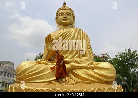 Le moine bouddhiste indien monte au sommet d'une statue géante de Bouddha, pour laver et décorer à la veille de Bouddha Purnima, une fête traditionnellement célébrée pour l'anniversaire de Bouddha également connu sous le nom de Vesak célébrations, à Howrah, Bengale occidental, Inde sur 15 mai 2021.Bouddha Purnima fête mai 16. (Photo de Debajyoti Chakraborty/NurPhoto) Banque D'Images