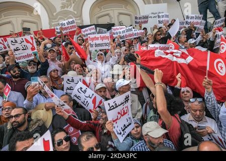 Les manifestants brandisquent un drapeau tunisien qui élève des pancartes qui lisent, ensemble en luttant pour la démocratie, contre le coup d'Etat du populisme lors d'une manifestation organisée par les partisans du mouvement des citoyens contre le coup d'Etat - l'Initiative démocratique, le Front national du Salut et le parti islamiste Ennahda, Sur l'avenue Habib Bourguiba à Tunis, en Tunisie, sur 15 mai 2022 pour protester contre le président tunisien Kais Saied et ses mesures exceptionnelles qu'il a prises depuis juillet 2021. Les manifestants ont appelé à la destitution du président Kais Saied et à la chute de ce qu'ils ont appelé le régime dictatorial et exigé Banque D'Images