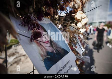 Les gens marchent devant un mur de fleurs avec des photos des victimes ukrainiennes de l'invasion russe à Varsovie, Pologne, le 17 mai 2022. Le conflit a causé environ 8000 mille victimes et plus de 6 millions de redevances dans ce que l'ONU a appelé la plus grande crise humanitaire en Europe depuis les guerres yougoslaves de 1990s. (Photo par STR/NurPhoto) Banque D'Images