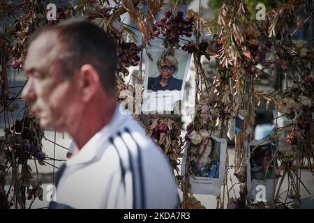 Les gens marchent devant un mur de fleurs avec des photos des victimes ukrainiennes de l'invasion russe à Varsovie, Pologne, le 17 mai 2022. Le conflit a causé environ 8000 mille victimes et plus de 6 millions de redevances dans ce que l'ONU a appelé la plus grande crise humanitaire en Europe depuis les guerres yougoslaves de 1990s. (Photo par STR/NurPhoto) Banque D'Images