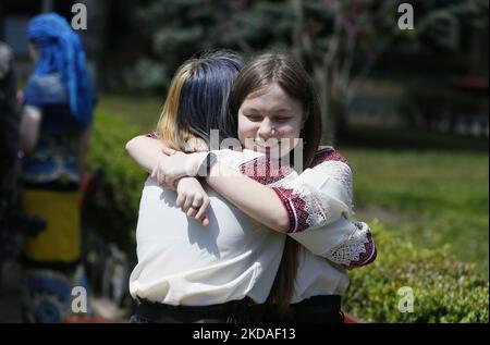 Les femmes ukrainiennes vêtues de vyshyvanka (chemise brodée) se embrassent lors de la journée de Vyshyvanka, au milieu de l'invasion russe en Ukraine, à Odesa, en Ukraine, le 19 mai 2022. Vyshyvanka Day est une fête internationale qui vise à préserver les traditions populaires originales de créer et de porter des vêtements ukrainiens brodés ethniques appelés vyshyvanka. (Photo par STR/NurPhoto) Banque D'Images