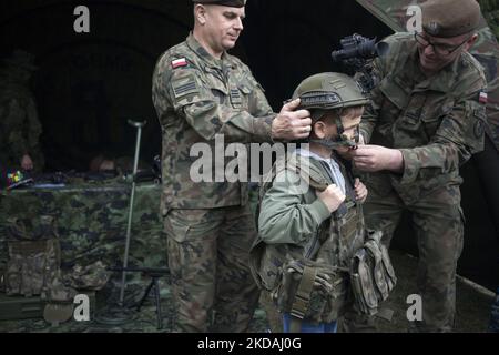 Les soldats habillent l'enfant en uniforme pendant le pique-nique de recrutement pour les Polands, nouveau service militaire général volontaire vu à Kozienice sur 21 mai 2022. (Photo de Maciej Luczniewski/NurPhoto) Banque D'Images