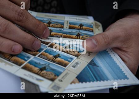 Un homme tient la dernière édition du timbre 'navire de guerre russe, Go f*** vous-même' devant le bureau de poste central de Kiev sur 23 mai 2022. Le timbre a été mis à jour pour inclure le mot « one » après que les forces ukrainiennes ont coulé le même navire de guerre. (Photo de Richard Wright/NurPhoto) Banque D'Images