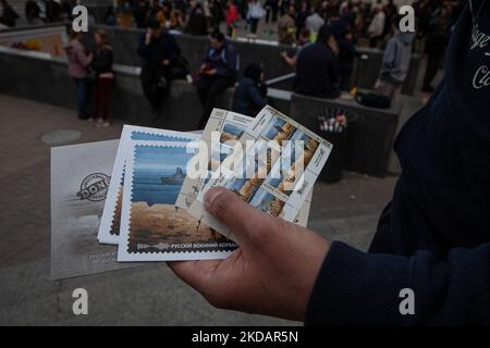 Un homme tient la dernière édition du timbre 'navire de guerre russe, Go f*** vous-même' devant le bureau de poste central de Kiev sur 23 mai 2022. Le timbre a été mis à jour pour inclure le mot « one » après que les forces ukrainiennes ont coulé le même navire de guerre. (Photo de Richard Wright/NurPhoto) Banque D'Images