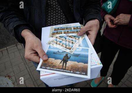 Un homme tient la dernière édition du timbre 'navire de guerre russe, Go f*** vous-même' devant le bureau de poste central de Kiev sur 23 mai 2022. Le timbre a été mis à jour pour inclure le mot « one » après que les forces ukrainiennes ont coulé le même navire de guerre. (Photo de Richard Wright/NurPhoto) Banque D'Images