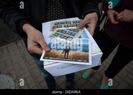 Un homme tient la dernière édition du timbre 'navire de guerre russe, Go f*** vous-même' devant le bureau de poste central de Kiev sur 23 mai 2022. Le timbre a été mis à jour pour inclure le mot « one » après que les forces ukrainiennes ont coulé le même navire de guerre. (Photo de Richard Wright/NurPhoto) Banque D'Images