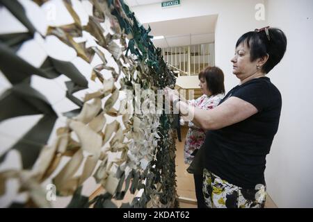 Les femmes serpentent des filets de camouflage pour les forces armées ukrainiennes, dans le cadre de l'invasion russe en Ukraine, à Odesa, en Ukraine, le 21 mai 2022. (Photo par STR/NurPhoto) Banque D'Images