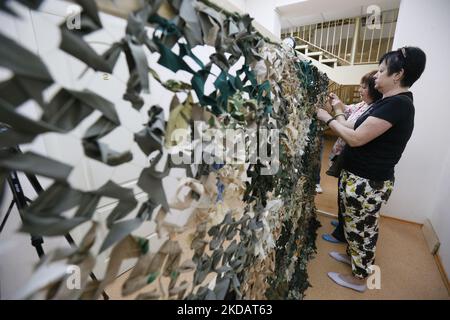 Les femmes serpentent des filets de camouflage pour les forces armées ukrainiennes, dans le cadre de l'invasion russe en Ukraine, à Odesa, en Ukraine, le 21 mai 2022. (Photo par STR/NurPhoto) Banque D'Images