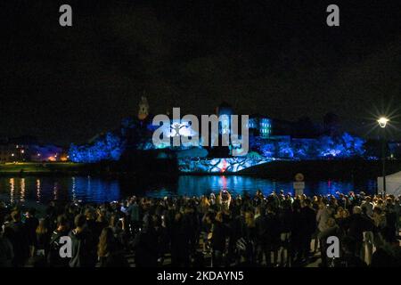 Les gens qui regardent le célèbre château de Wawel illuminé pendant le spectacle de lumière de Stranger Things 4. Aujourd'hui, à la veille de la sortie de la quatrième saison de la série américaine d'horreur de science-fiction intitulée Stranger Things 4, Netflix a organisé des spectacles de lumière dans plusieurs villes du monde, y compris à New York, Milan, Australie, Cracovie, Tokyo, Bombay, Cologne, Kuala Lumpur, Al-Ula, Londres, Barcelone, Madrid, Stockholm et Utrecht. Jeudi, 26 mai 2022, à Cracovie, petite Pologne Voivodeship, Pologne. (Photo par Artur Widak/NurPhoto) Banque D'Images