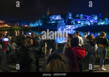 Les gens qui regardent le célèbre château de Wawel illuminé pendant le spectacle de lumière de Stranger Things 4. Aujourd'hui, à la veille de la sortie de la quatrième saison de la série américaine d'horreur de science-fiction intitulée Stranger Things 4, Netflix a organisé des spectacles de lumière dans plusieurs villes du monde, y compris à New York, Milan, Australie, Cracovie, Tokyo, Bombay, Cologne, Kuala Lumpur, Al-Ula, Londres, Barcelone, Madrid, Stockholm et Utrecht. Jeudi, 26 mai 2022, à Cracovie, petite Pologne Voivodeship, Pologne. (Photo par Artur Widak/NurPhoto) Banque D'Images