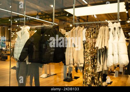 Hommes vêtements décontractés sur les étagères et les cintres dans un magasin de centre commercial. Une pile de vestes dans un centre commercial. Présentoir de tablettes dans un centre commercial. Banque D'Images