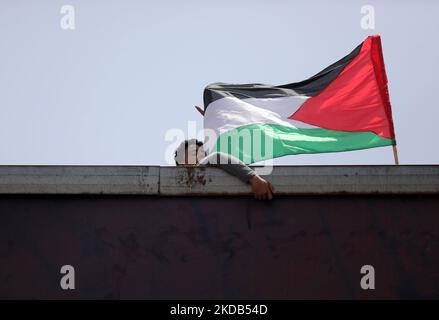 Les Palestiniens lèvent les drapeaux nationaux dans la ville de Gaza sur 29 mai 2022, avant le début de la marche des drapeaux pour marquer le jour de Jérusalem, qui commémore l'unification de la ville après qu'Israël a annexé Jérusalem-est en 1967. (Photo de Majdi Fathi/NurPhoto) Banque D'Images