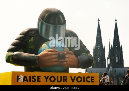 Un flotteur avec une police couvrant l'embouchure de la planète est vu derrière la cathédrale de la Cologne à Cologne, en Allemagne, sur 4 juin 2022, lors de l'action "élever votre voix" d'Amnesty international Koeln. (Photo de Ying Tang/NurPhoto) Banque D'Images