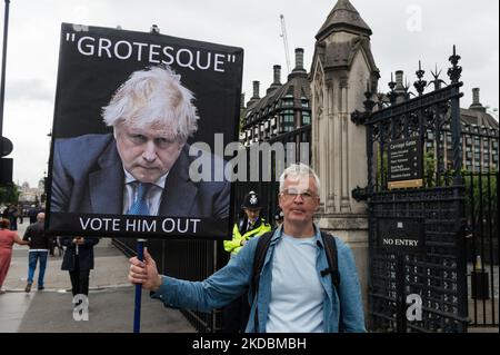 LONDRES, ROYAUME-UNI - le 06 JUIN 2022 : un démonstrateur tient un écriteau à l'extérieur des chambres du Parlement tandis que les députés du Parti conservateur déposent leur bulletin dans un vote de confiance du Premier ministre Boris Johnson sur 06 juin 2022 à Londres, en Angleterre. Le vote de confiance a été déclenché après qu'au moins 54 députés aient soumis leurs lettres de censure à l'égard de Boris Johnson à Sir Graham Brady, président du comité conservateur 1922 de l'arrière-ban, à la suite de la publication du rapport de Sue Gray sur les partis de non-respect des règles du confinement de Covid à Downing Street. (Photo de Wiktor Szymanowicz/NurPhoto) Banque D'Images