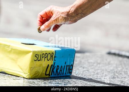 Une personne met une pièce dans une boîte à monnaie avec des écrits de 'l'Ukraine de soutien' lors de la manifestation de 'l'OTAN Fermer le ciel" à Cracovie, en Pologne sur 7 juin 2022. (Photo de Jakub Porzycki/NurPhoto) Banque D'Images