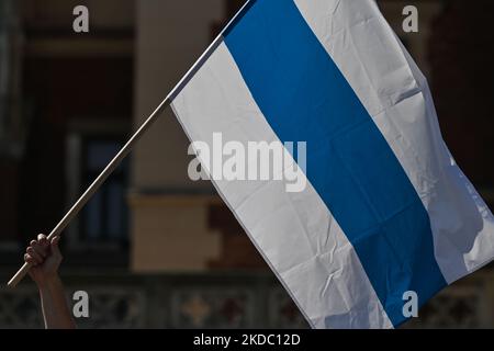 Un manifestant détient le drapeau blanc-bleu-blanc, le nouveau drapeau du mouvement anti-guerre de la Russie les membres de la diaspora russe locale de Cracovie se joignent à la manifestation anti-guerre mondiale de tous les Russes libres et protestent contre la guerre avec l'Ukraine au monument Adam Mickiewicz sur la place principale de Cracovie. Dimanche, 12 juin 2022, à Cracovie, en Pologne. (Photo par Artur Widak/NurPhoto) Banque D'Images